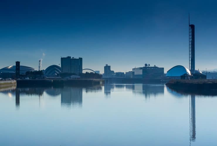 The skyline of Glasgow reflected in the water.