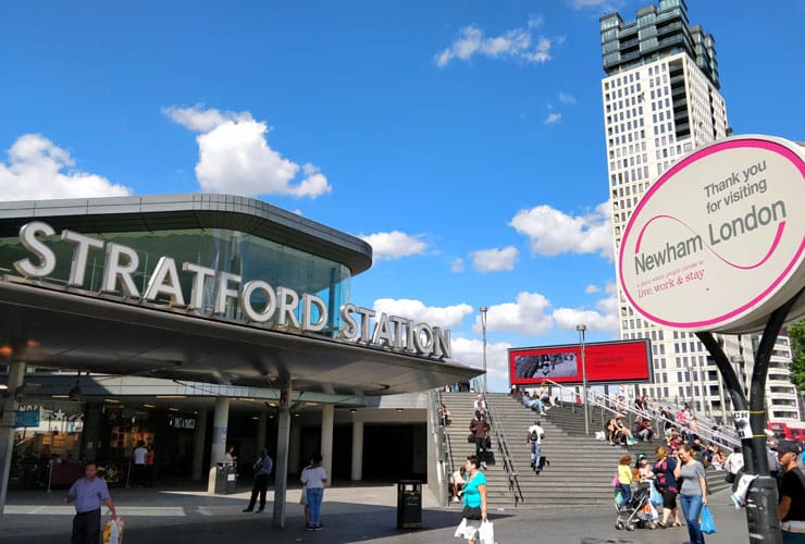 The entrance of Stratford Station, next to a Newham London sign.