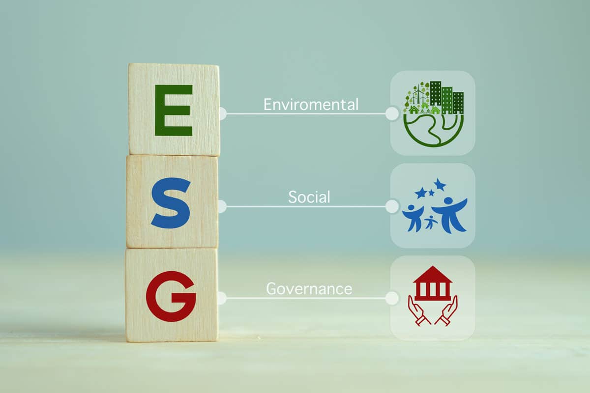 SG concept of environmental, social and governance. Sustainable corporation development. Wooden cubes with abbreviation ESG standing with other ESG icons on grey background.