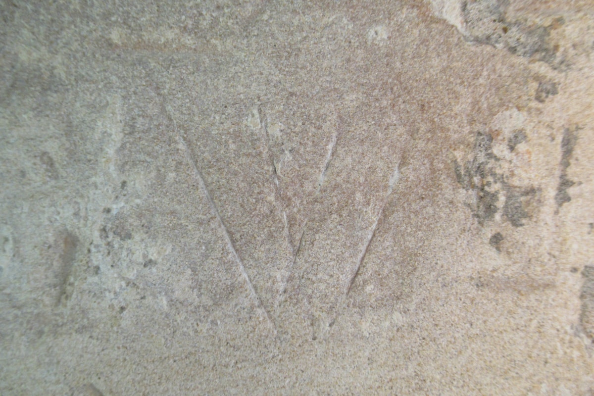 Ancient witch marks carved into stone on an English medieval door frame, from the fifteenth century.