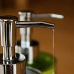 A close up photograph of two soap dispensers.