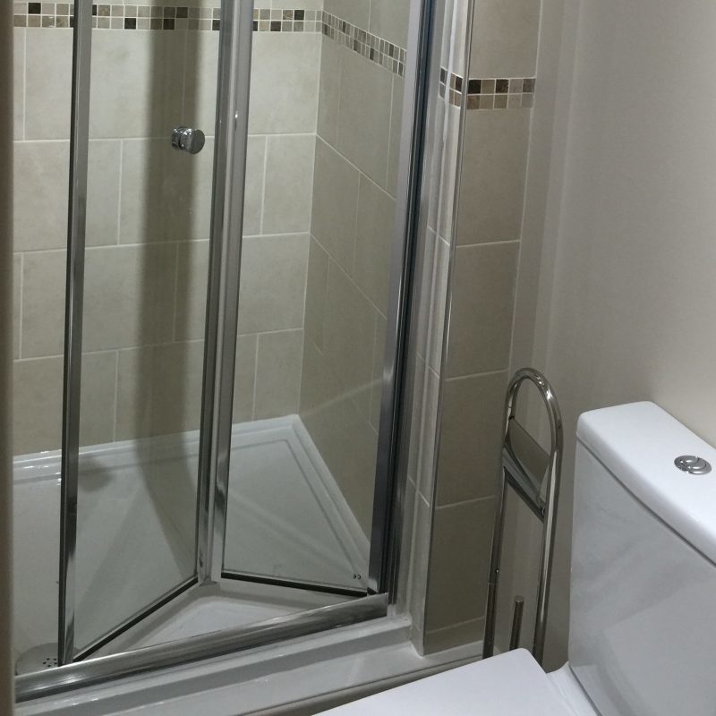 A shower and a toilet in an en suite bathroom.