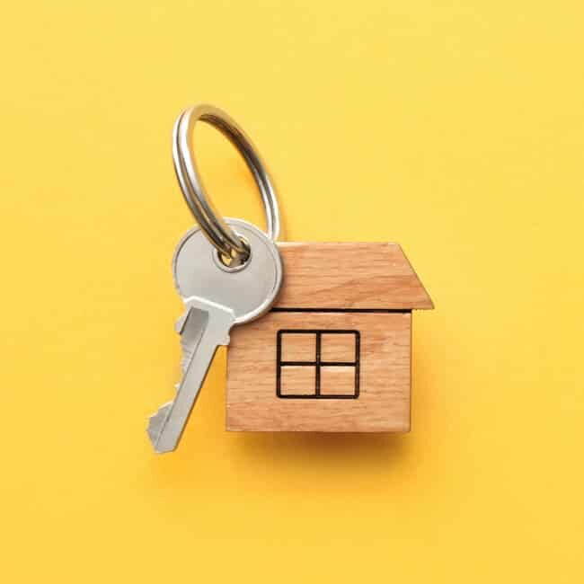 A keyring and house key. Represents buying or selling a home.