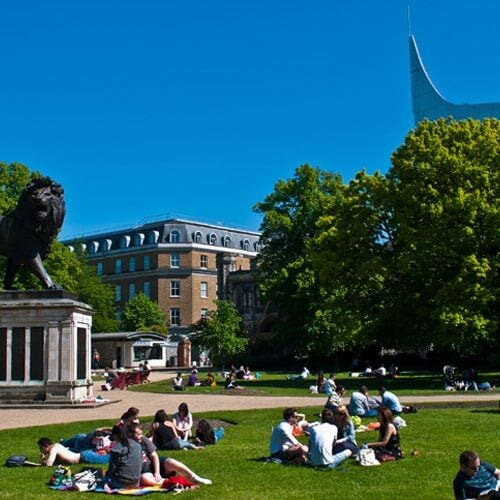 Groups of young people sat in a park on a summer day. Photograph taken in Forbury Gardens in Reading, UK.