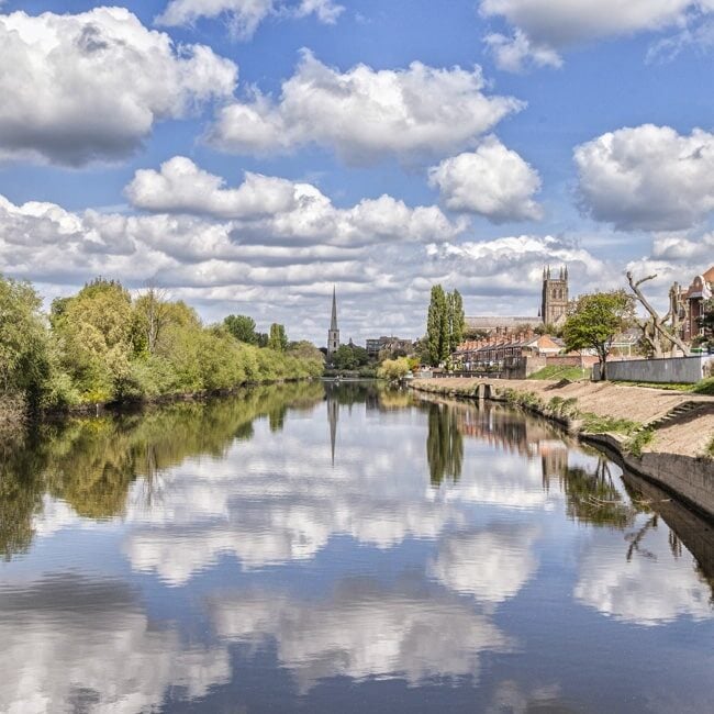 Clouds reflected in the River Severn with the city of Worcester in the background.