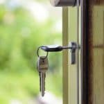 A key sits in the lock of a door.