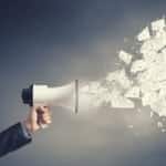 A megaphone shoots out pieces of paper. The image represents the power of leaflet and direct mail focussed marketing.