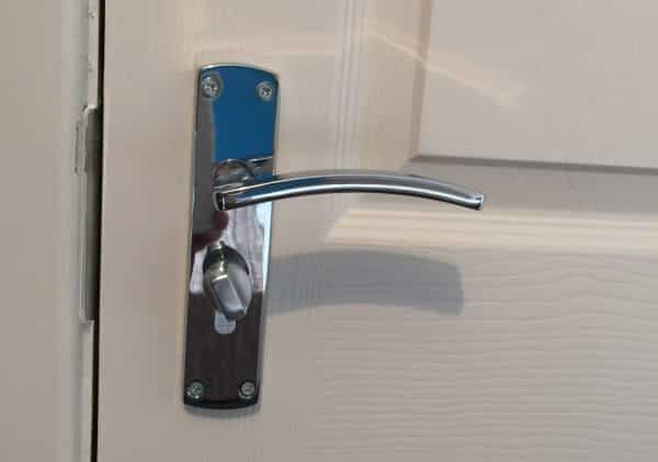 Close up photo of a door handle and a thumb-turn lock. Thumb-turn locks are an essential part of fire safety and HMO fire regulations.